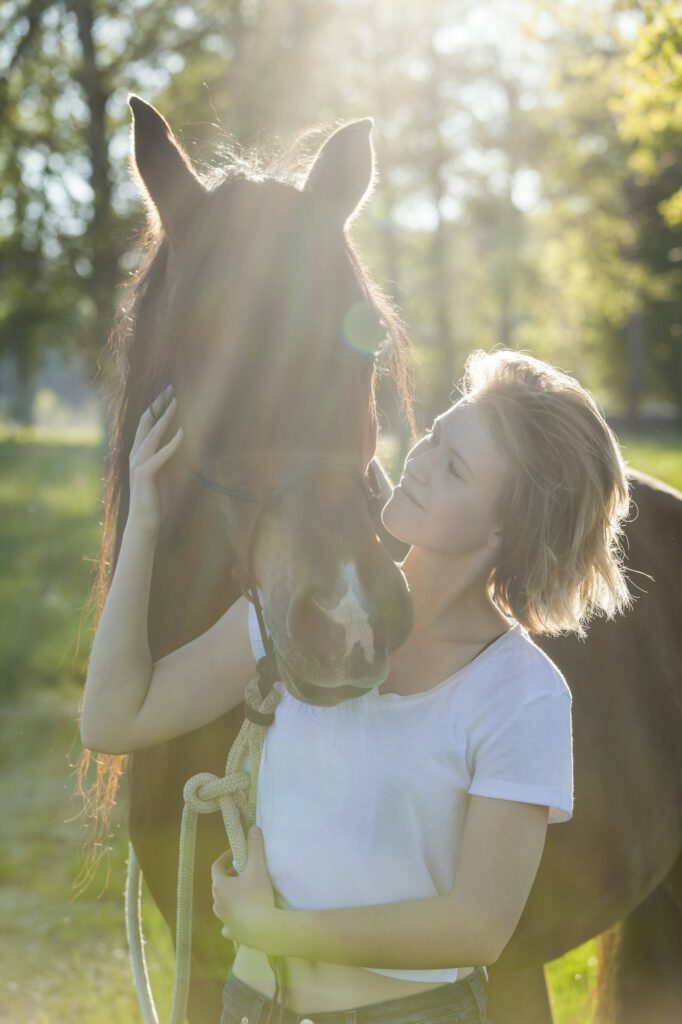 Young woman with horse at backlight